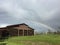 Vivid low Rainbow and barn with green grass