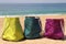 Vivid multicolored beach bags on the seashore