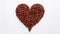 A vivid portrayal of a large brown heart crafted from coffee beans, impaled by a brown arrow with r