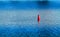 Vivid red buoy on river surface background