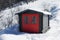 Vivid red hut on snow covered mountain in winter