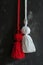 Vivid red and pure white Martisor tassels against dark textured grunge background. Moldavian, Romanian tradition 1 March