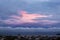 Vivid sky of pink and blue colors during sundown. Beautiful skyscape with clouds at the sunset time over a seaside city. Evening