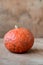 Vivid small orange pumpkin on wooden background