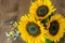 Vivid sunflower bouquet closeup on the wooden background