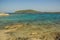 Vivid tropic sea lagoon with colorful blue and green calm water surface near stone rocky picturesque waterfront shoreline beach