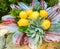 vivid yellow lemons with assorted mediterranean herbs in a flower shaped bowl