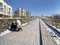 Vladivostok, Russia, March, 13,2020.  Young woman with a child in a stroller sits on the bench on the embankment in the Bay of Pat