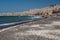 Vlychada beach with black sand below the bizarre shaped cliff