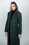 Vogue female coat. Young glamour woman wearing stylish fashion dress. Fashion model in studio.