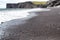 Volcanic black sand and volcanic rocks on the Iceland beach