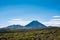 Volcanic cone of Mount Ngauruhoe rising over flat plateau on a fine summer day