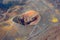 Volcanic crater on the side of the mountain, around hardened lava. Aerial view