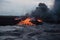 volcanic eruption, with view of lava flow overflowing river and scorching the earth in its path