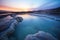 a volcanic hot spring appearing to glow in dusk light