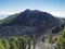 Volcanic landscape with lush green pine trees, colorful volcanoes and lava crater Deseada along path Ruta de los