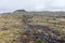 Volcanic landscape with a small volcano at the back.