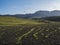 Volcanic landscape with snow covered mountains, green hills and lava gravel ground covered by lush moss. Fjallabak