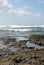 Volcanic ocean coast with waves and blue sky