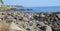 Volcanic stones on the seashore, great volcanic rocks on the Ionian sea, seashore, palm trees on the seashore