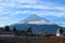 Volcano Agua above the roofs of old quarters of Antigua with clouds resting on it