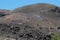 Volcano: black scorched earth, volcanic stones, many people walking the trail