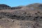 Volcano: black scorched earth, volcanic stones, many people walking the trail