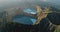 Volcano crater lake landscape aerial panorama. Blue water reservoir in morning sunrise light.