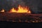 Volcano eruption at Meradalir near Fagradalsfjall, Iceland. Erupting magma and flowing lava at night.