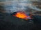 Volcano in eruption, red hot magma boiling in crater, aerial side view