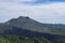 Volcano landscape with lava fields, pine tree forest and farms and houses on the slopes. Kintamani is a village on the western