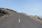 Volcano road in arid island. Straight driveway in rocky landscaped. Asphalt route in black rural field. Canary Island lonely way