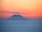 Volcano Stromboli at sunset on the blue sea