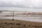 A volleyball net stands abandoned as Tropical Storm Nate turns the waters of the Pacific red from storm run off.