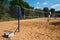 Volleyball nets on blue poles with concrete weights for balance