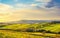 Volterra panorama, rolling hills, green fields and white road. Tuscany, Italy