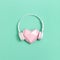 Volumetric paper pink heart in white headphones. Concept for music festivals, radio stations, music lovers