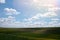 Voluminous white clouds in the blue sky, beautiful summer landscape, fields in the village.