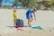 Volunteer blue face mask forest sand beach. Son helps father hold black bag for pick up garbage. Problem spilled rubbish