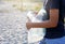 Volunteer boy in blue t shirt picks up dirty plastic bottles in park. Hands in yellow gloves collect garbage, pick up trash in bag