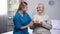 Volunteer celebrating birthday with elderly lady holding cake, patient care