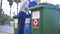 Volunteer checking garbage in waste bins for separate trash collection on Mediterranean resort. Young Caucasian woman