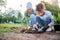 Volunteer, child and woman with plant for gardening in park with trees in nature environment. Happy family team helping