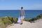 Volunteer cleaning beach from plastic. Kid looking around, picking up plastic bottles trash and putting into plastic bag