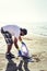 Volunteer collecting plastics on the shore