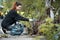 volunteer female cleaning up park and tree from plastic litter with garbage bag