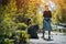 volunteer female cleaning up park and tree from plastic litter with garbage bag