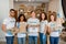 Volunteer office. Group portrait of multiracial people carrying donation boxes, posing indoors and smiling to camera