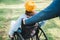 Volunteer pushes the wheelchair of a young disabled girl in a garden