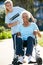 Volunteer Pushing Senior Woman In Wheelchair